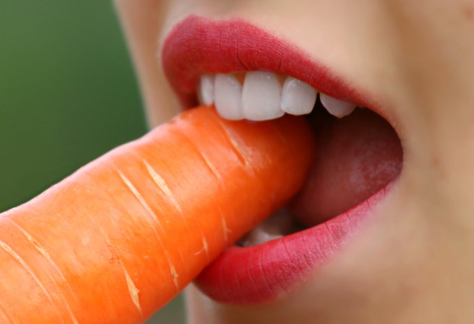 osoba jedząca marchewkę